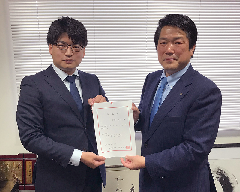 Modisの古家と南伊豆町と岡部町長が、二人で委嘱書を持っている
。