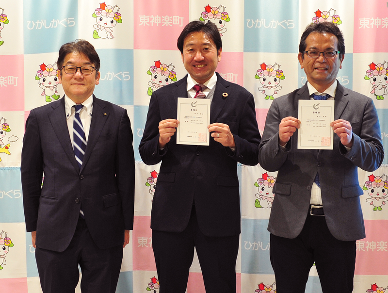 並んで立つ3人の男性。右側の二人は委嘱状を持っている。