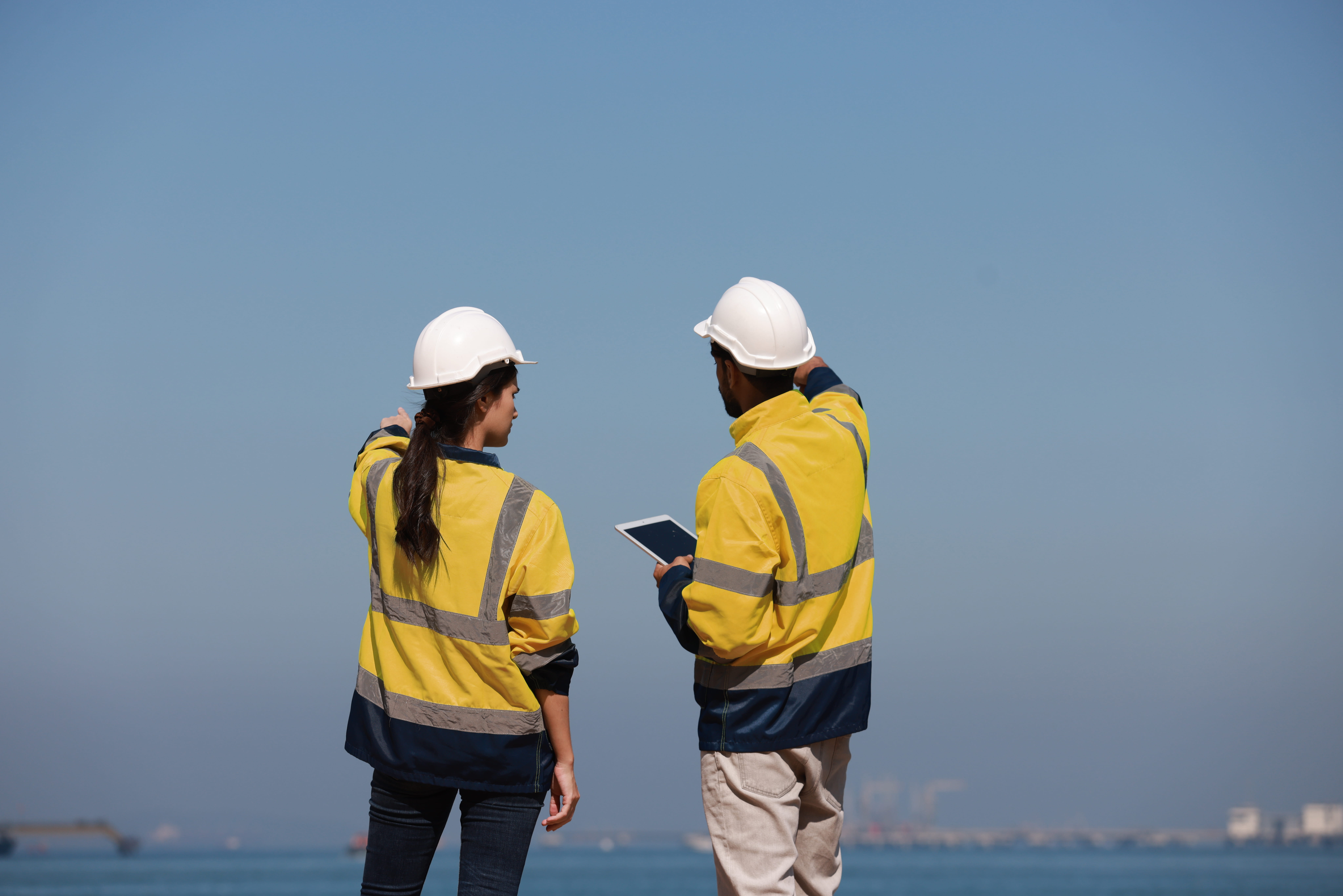 A woman and a man in work clothes standing on a shore