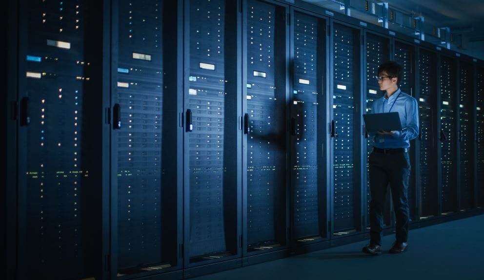 man standing front of data servers
